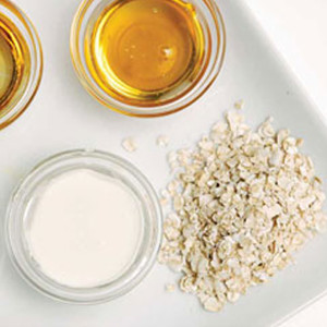 An aerial close-up shot of the ingredients oatmeal, milk and honey.